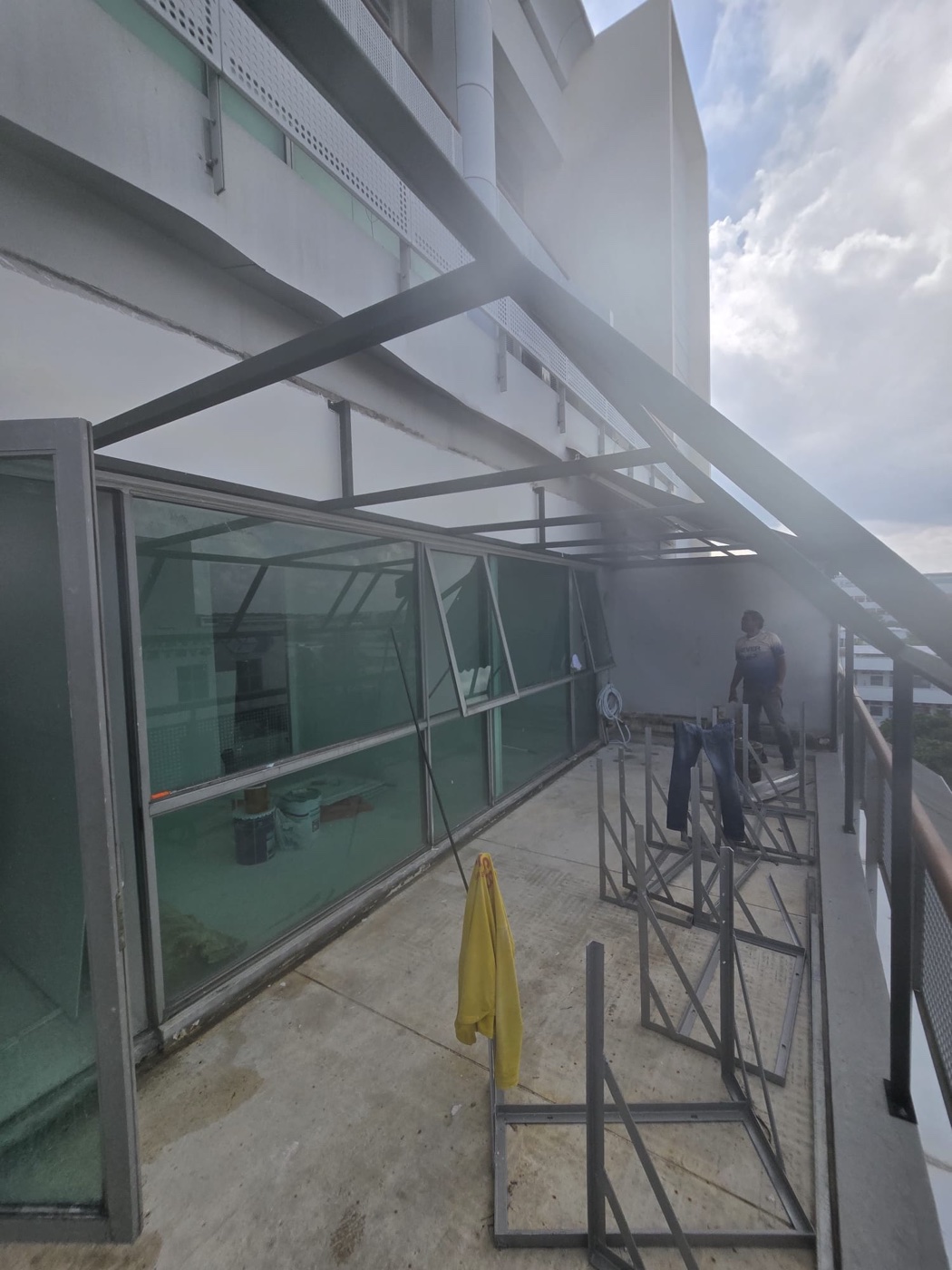 Qair technician on a commercial rooftop inspecting the condenser unit