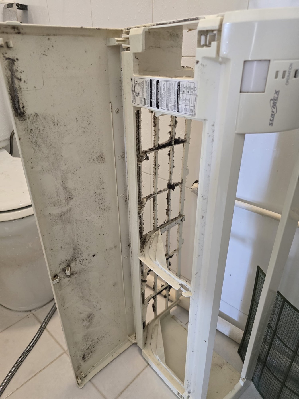 Aircon cover and fan blades covered in grime before chemical wash